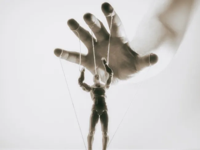 puppet master controlling wood puppet